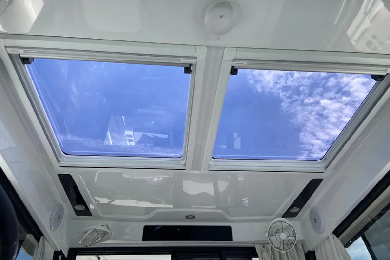 Slide: The Image of 2024 Jeanneau NC Weekender 895 Series 2 skylight view with blue sky and clouds. - 22