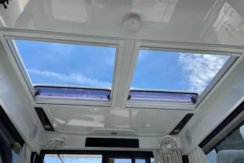 Slide: The Image of 2024 Jeanneau NC Weekender 895 Series 2 interior with open sunroof and blue sky view. - 23
