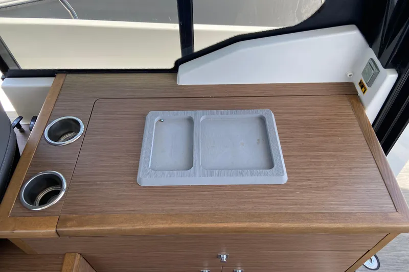Slide: The Image of 2024 Jeanneau NC Weekender 895 Series 2 interior with wooden countertop and cup holders. - 25