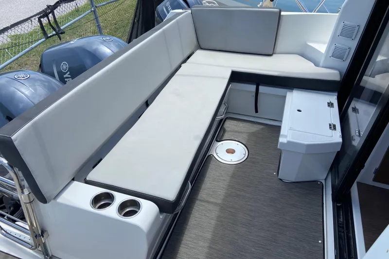 Slide: The Image of 2024 Jeanneau NC Weekender 895 Series 2 boat interior with cushioned seating and cup holders. - 3