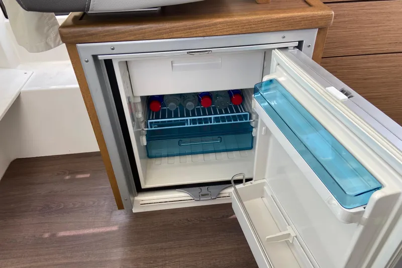 Slide: The Image of Compact fridge inside 2024 Jeanneau NC Weekender 895 Series 2 boat, stocked with bottles. - 31