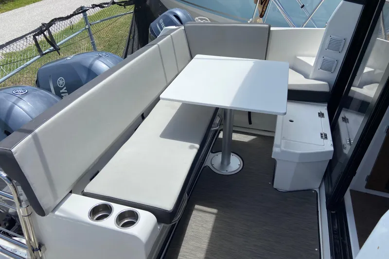 Slide: The Image of 2024 Jeanneau NC Weekender 895 Series 2 boat seating area with table and cup holders. - 4
