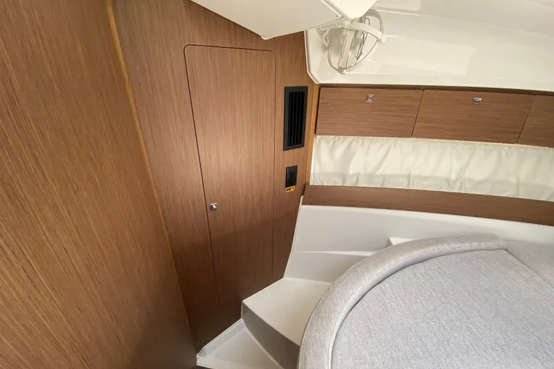 Slide: The Image of Interior of 2024 Jeanneau NC Weekender 895 Series 2, featuring wood paneling and cozy seating. - 41