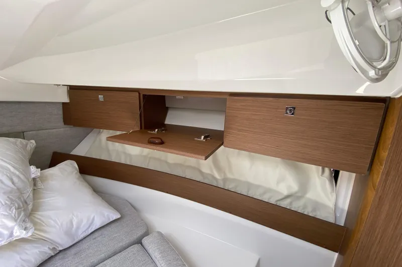 Slide: The Image of 2024 Jeanneau NC Weekender 895 Series 2 cabin with wooden storage cabinets and cozy bedding. - 46
