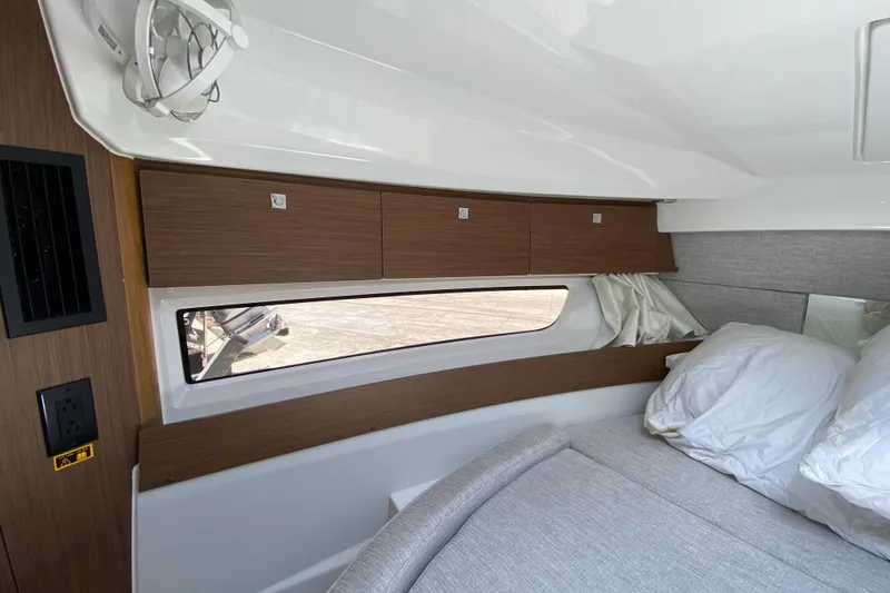 Slide: The Image of 2024 Jeanneau NC Weekender 895 Series 2 cabin interior with wood cabinets and bedding. - 47