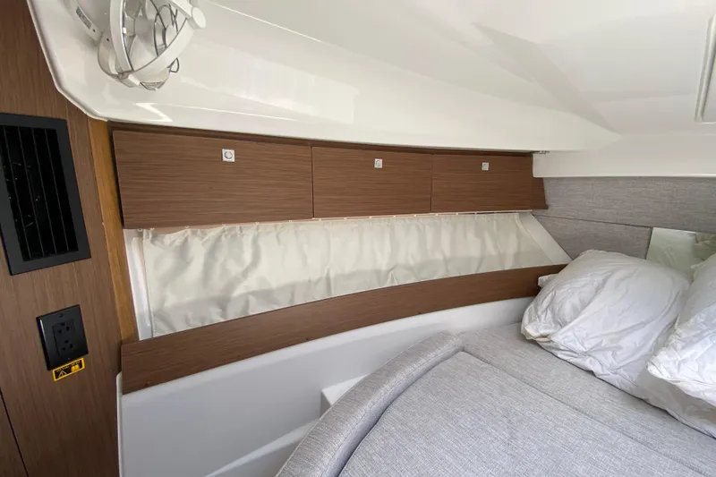 Slide: The Image of 2024 Jeanneau NC Weekender 895 Series 2 cabin interior with wood paneling and cozy bedding. - 48