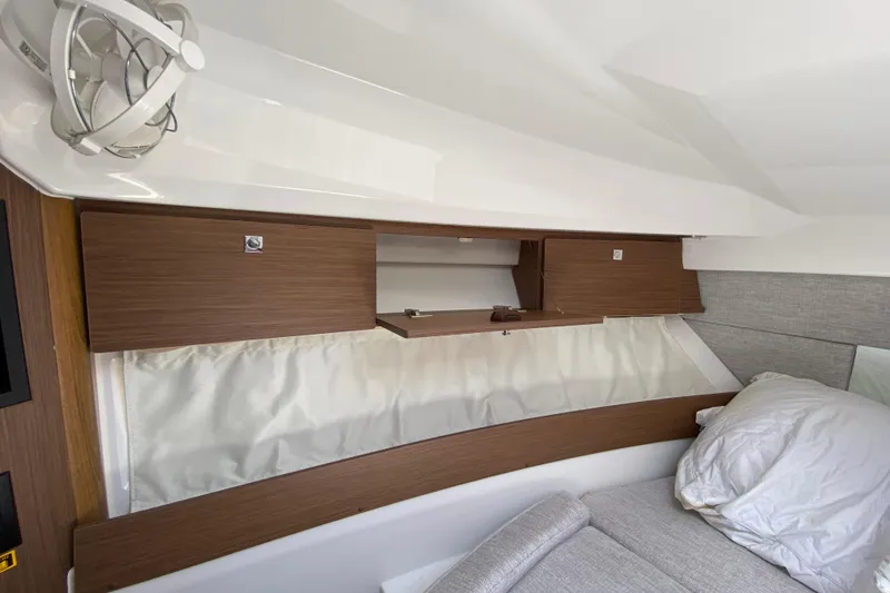 Slide: The Image of 2024 Jeanneau NC Weekender 895 Series 2 cabin interior with wooden storage and cozy bedding. - 50