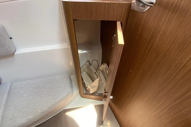 Slide: The Image of Interior view of 2024 Jeanneau NC Weekender 895 Series 2, featuring a wooden cabinet and seating. - 57