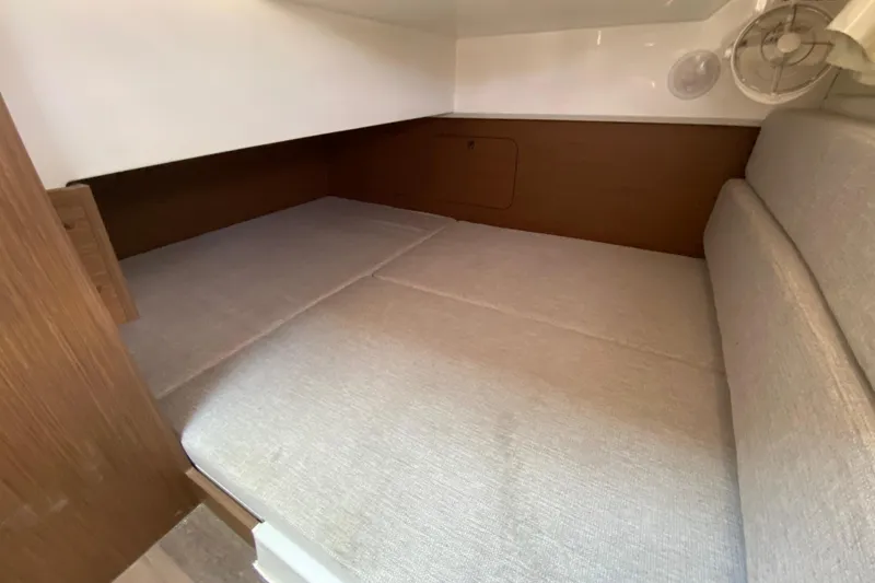 Slide: The Image of 2024 Jeanneau NC Weekender 895 Series 2 cabin interior with cozy bedding and wood accents. - 58