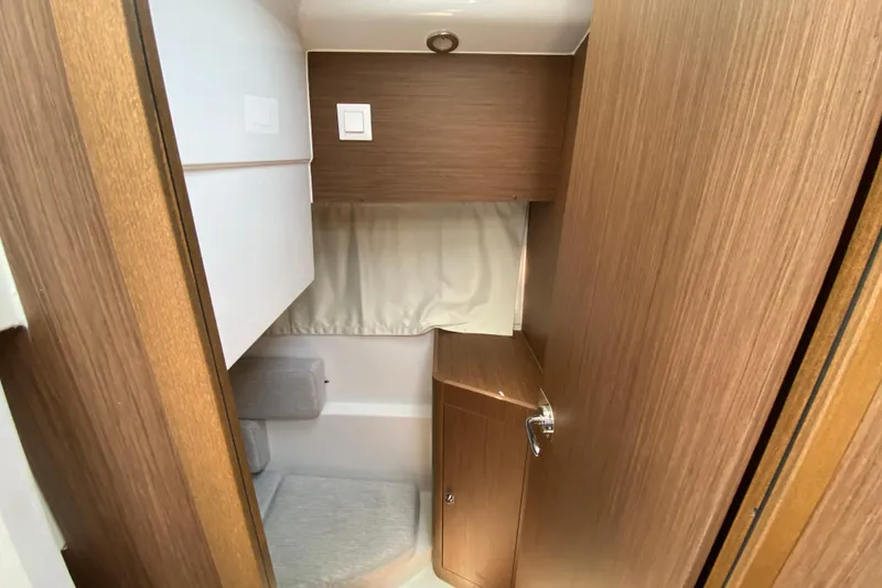 Slide: The Image of 2024 Jeanneau NC Weekender 895 Series 2 cabin interior with wood finish and cozy seating. - 59
