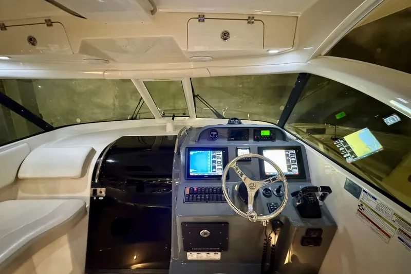 Slide: The Image of 2014 Pursuit OS 345 Offshore boat cockpit with modern navigation equipment and steering wheel. - 2