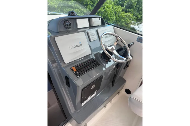 Slide: The Image of Helm of 2014 Pursuit OS 345 Offshore with Garmin navigation system and steering wheel. - 1