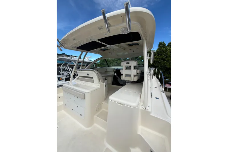 Slide: The Image of 2014 Pursuit OS 345 Offshore boat interior with seating and helm, under a clear blue sky. - 2