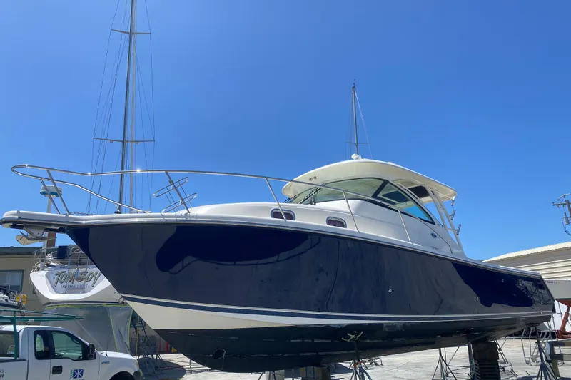 Slide: The Image of 2014 Pursuit OS 345 Offshore boat on dry dock under clear blue sky. - 4