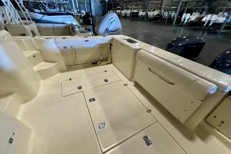 Slide: The Image of 2014 Pursuit OS 345 Offshore boat interior with storage compartments and Yamaha engines. - 9