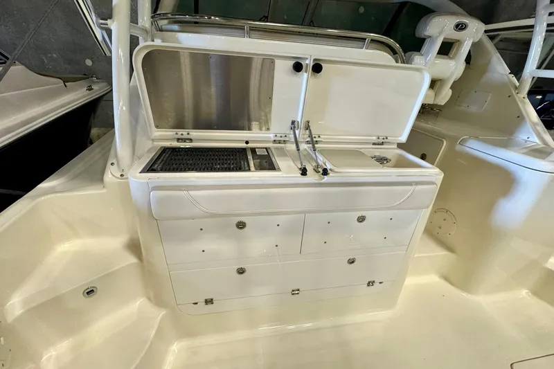 Slide: The Image of 2014 Pursuit OS 345 Offshore boat interior with storage compartments and sink. - 12
