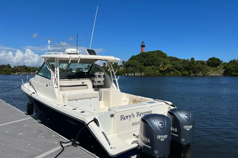 Slide: The Image of 2014 Pursuit OS 345 Offshore boat docked by a scenic lighthouse. - 6