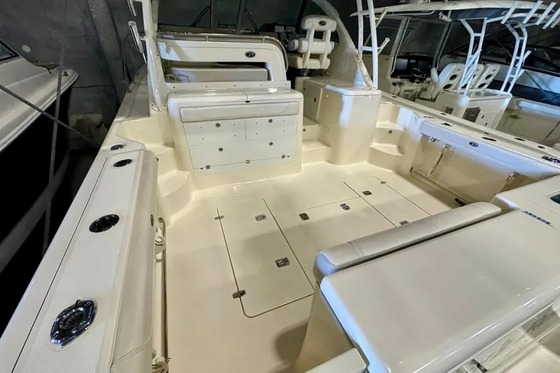 Slide: The Image of 2014 Pursuit OS 345 Offshore boat interior with spacious seating and storage compartments. - 7