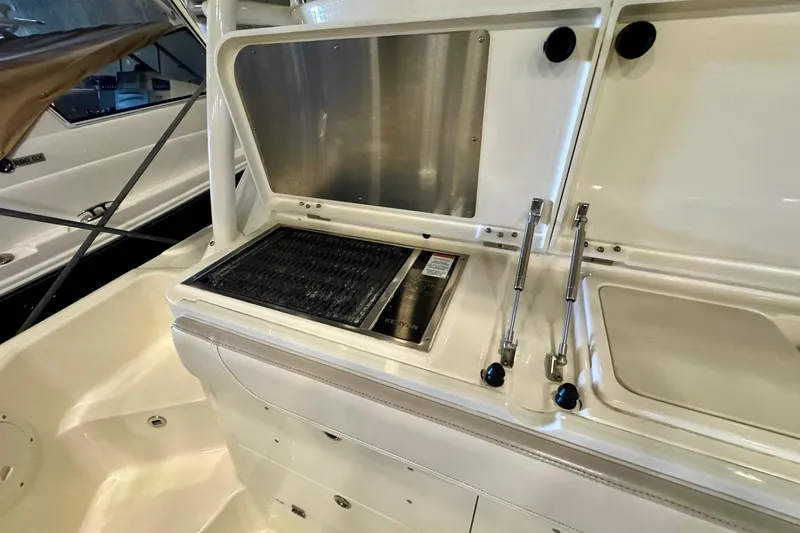 Slide: The Image of 2014 Pursuit OS 345 Offshore boat interior with grill and storage compartments. - 13