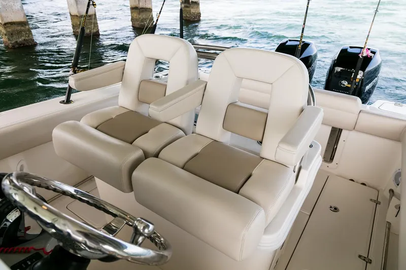 Slide: The Image of Manufacturer Provided Image: 2025 Boston Whaler 250 Outrage boat interior with plush seating and dual outboard motors. - 16