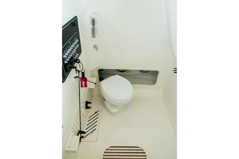 Slide: The Image of Manufacturer Provided Image: Interior of 2025 Boston Whaler 250 Outrage boat, featuring a compact marine toilet. - 20