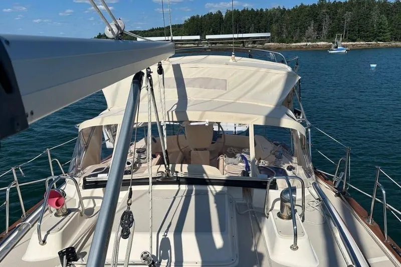 Slide: The Image of 2015 Island Packet 370 sailboat with canopy, docked in serene waters. - 11
