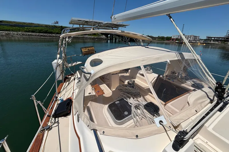 Slide: The Image of 2015 Island Packet 370 sailboat docked, featuring a spacious cockpit and protective canopy. - 13