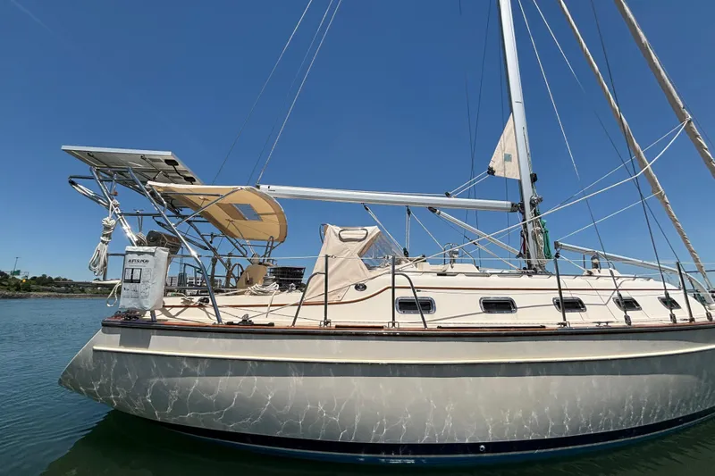 Slide: The Image of 2015 Island Packet 370 sailboat on calm water under clear blue sky. - 15