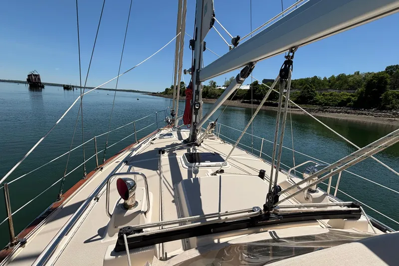 Slide: The Image of 2015 Island Packet 370 sailboat deck with clear blue water and shoreline view. - 16