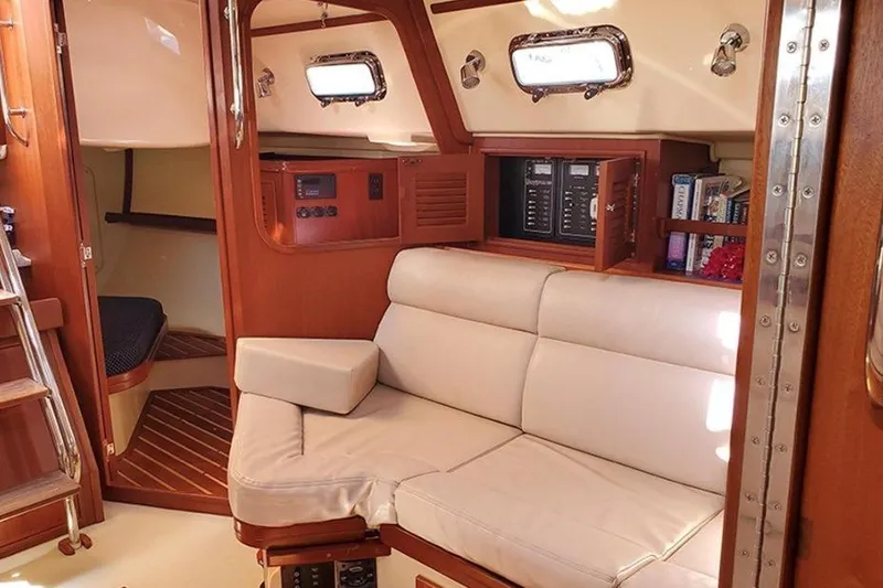 Slide: The Image of Interior of a 2015 Island Packet 370 sailboat with cozy seating and wooden cabinetry. - 29