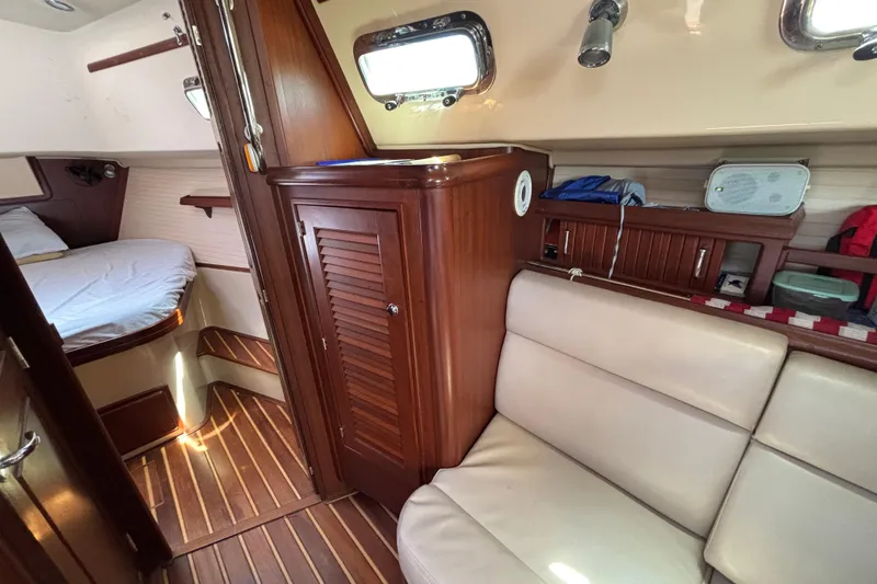 Slide: The Image of Interior of 2015 Island Packet 370 sailboat with wood cabinetry and cozy seating area. - 31