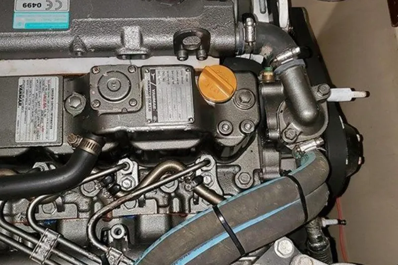 Slide: The Image of Engine of a 2015 Island Packet 370 sailboat, showcasing mechanical components and hoses. - 45
