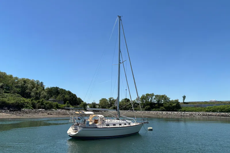 Slide: The Image of Sailboat Island Packet 370 (2015) anchored in a serene coastal inlet under clear blue skies. - 5
