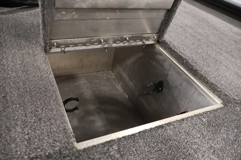 Slide: The Image of Open storage compartment in 2024 Tracker Pro 170 boat, featuring carpeted interior. - 16