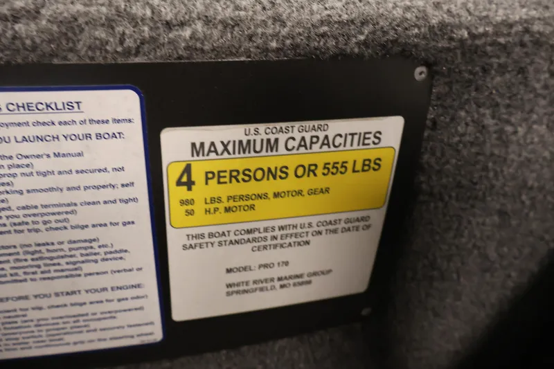 Slide: The Image of 2024 Tracker Pro 170 capacity label: 4 persons or 555 lbs, U.S. Coast Guard compliant. - 26