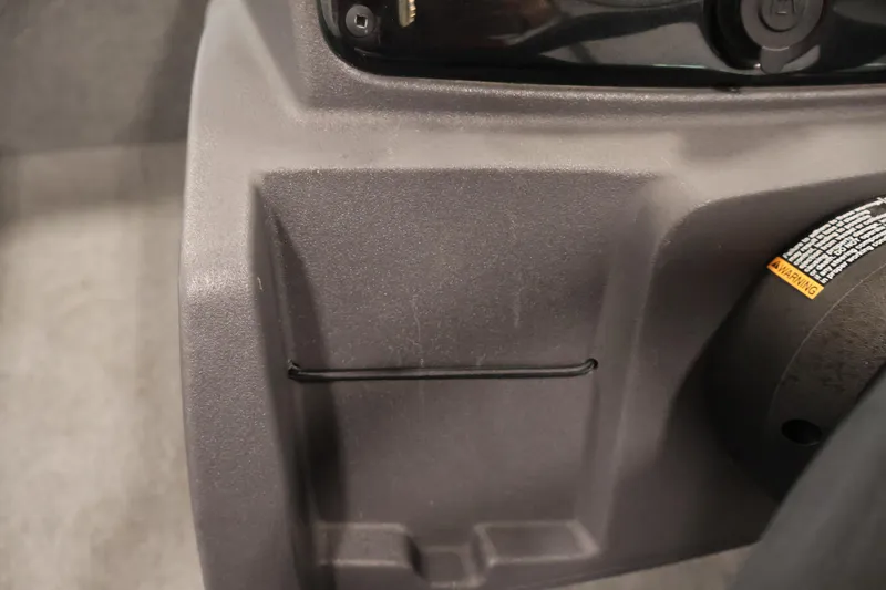 Slide: The Image of 2024 Tracker Pro 170 interior detail with warning label and storage compartment. - 27