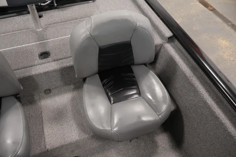 Slide: The Image of 2024 Tracker Pro 170 boat seat, featuring gray and black upholstery, on a carpeted deck. - 29