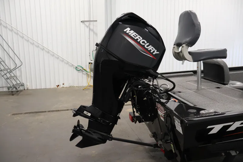 Slide: The Image of 2024 Tracker Pro 170 boat with Mercury outboard motor in a garage setting. - 34