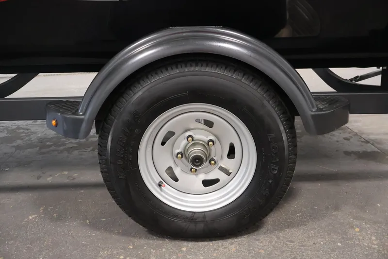 Slide: The Image of 2024 Tracker Pro 170 trailer wheel with black tire and silver rim. - 39