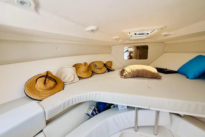 Slide: The Image of Cozy cabin interior of 2003 Intrepid 377 boat with hats and cushions. - 101