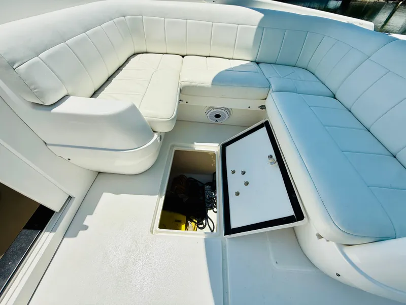 Slide: The Image of 2003 Intrepid 377 boat with white cushioned seating and open storage compartment. - 15
