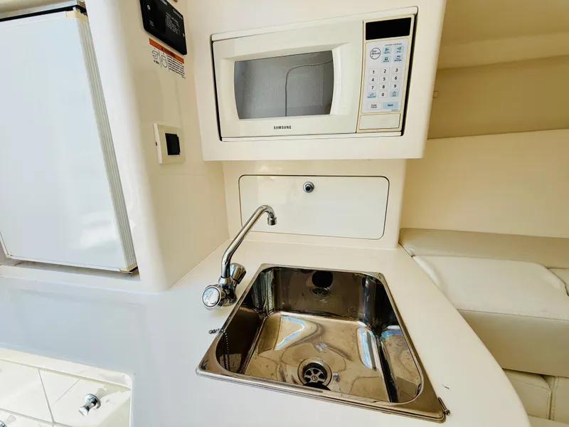 Slide: The Image of Compact kitchen area in a 2003 Intrepid 377 boat with sink and microwave. - 18
