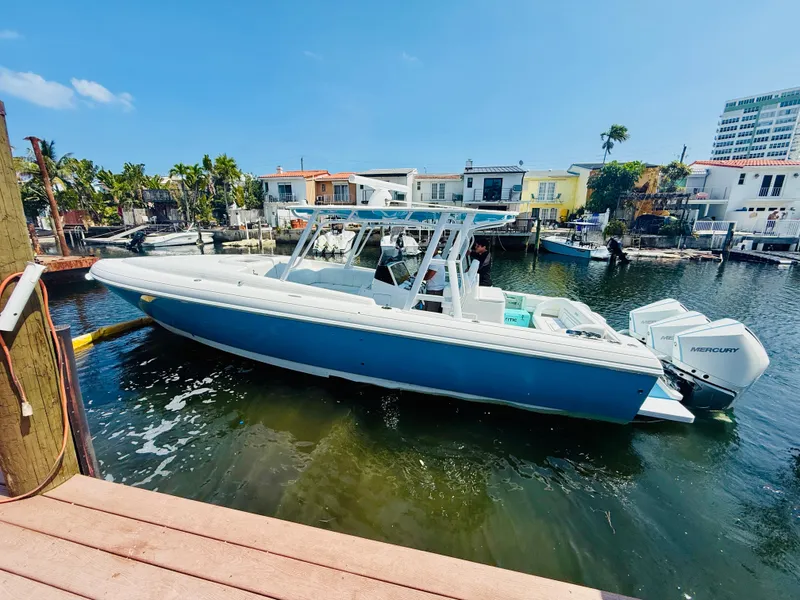 Slide: The Image of 2003 Intrepid 377 boat docked in a sunny waterfront neighborhood. - 2