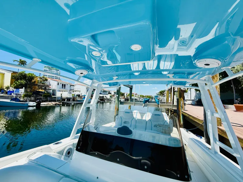 Slide: The Image of 2003 Intrepid 377 boat with blue canopy, docked in a sunny marina. - 24