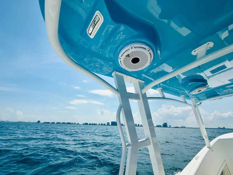 Slide: The Image of 2003 Intrepid 377 boat on open water, featuring blue canopy and ocean view. - 35
