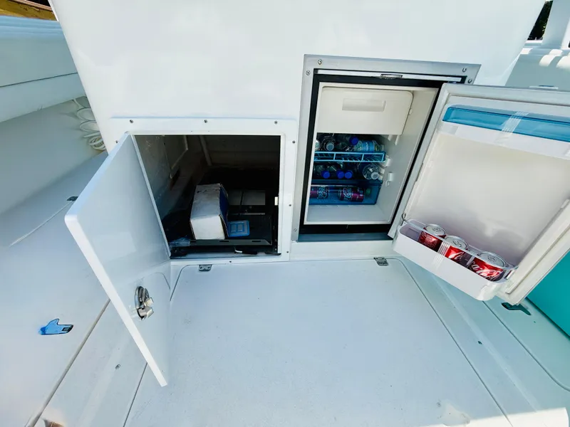 Slide: The Image of 2003 Intrepid 377 boat with open storage compartments and stocked mini fridge. - 40