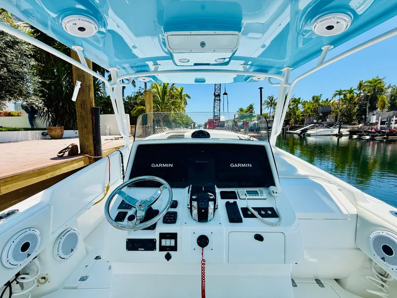 Slide: The Image of 2003 Intrepid 377 boat cockpit with Garmin navigation, docked by a scenic canal. - 42