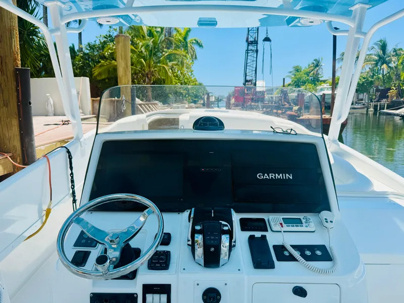 Slide: The Image of 2003 Intrepid 377 boat dashboard with Garmin navigation, steering wheel, and communication equipment. - 43