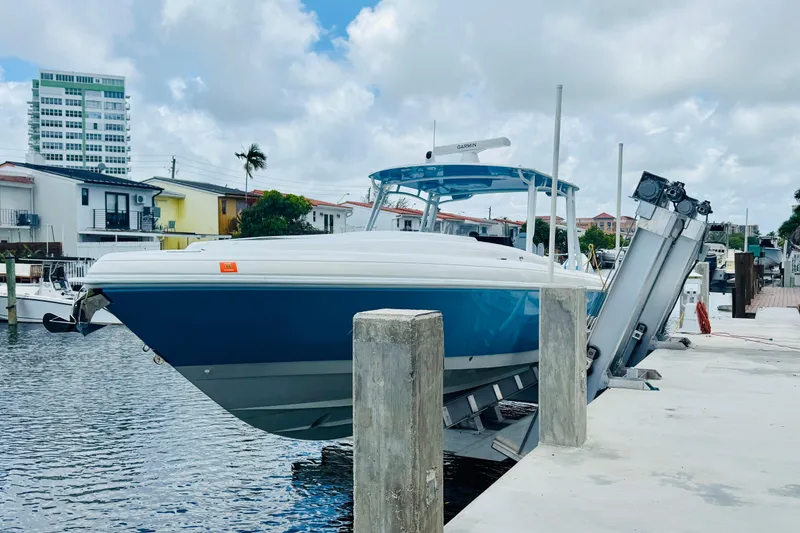 Slide: The Image of 2003 Intrepid 377 boat docked at marina with modern buildings in background. - 47