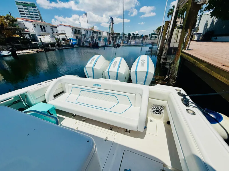 Slide: The Image of 2003 Intrepid 377 boat with triple engines docked in a marina under a blue sky. - 48